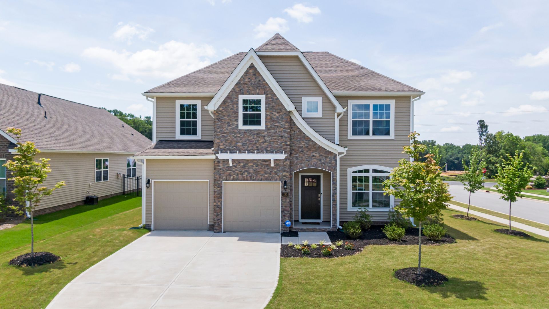 A two story house with a driveway in front of it