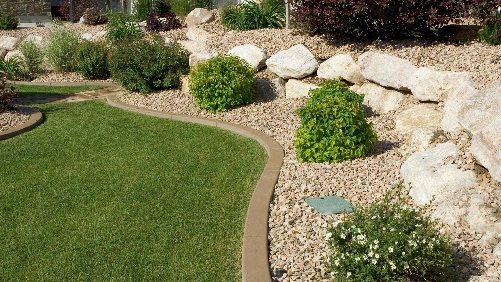 A garden with rocks, grass, and plants