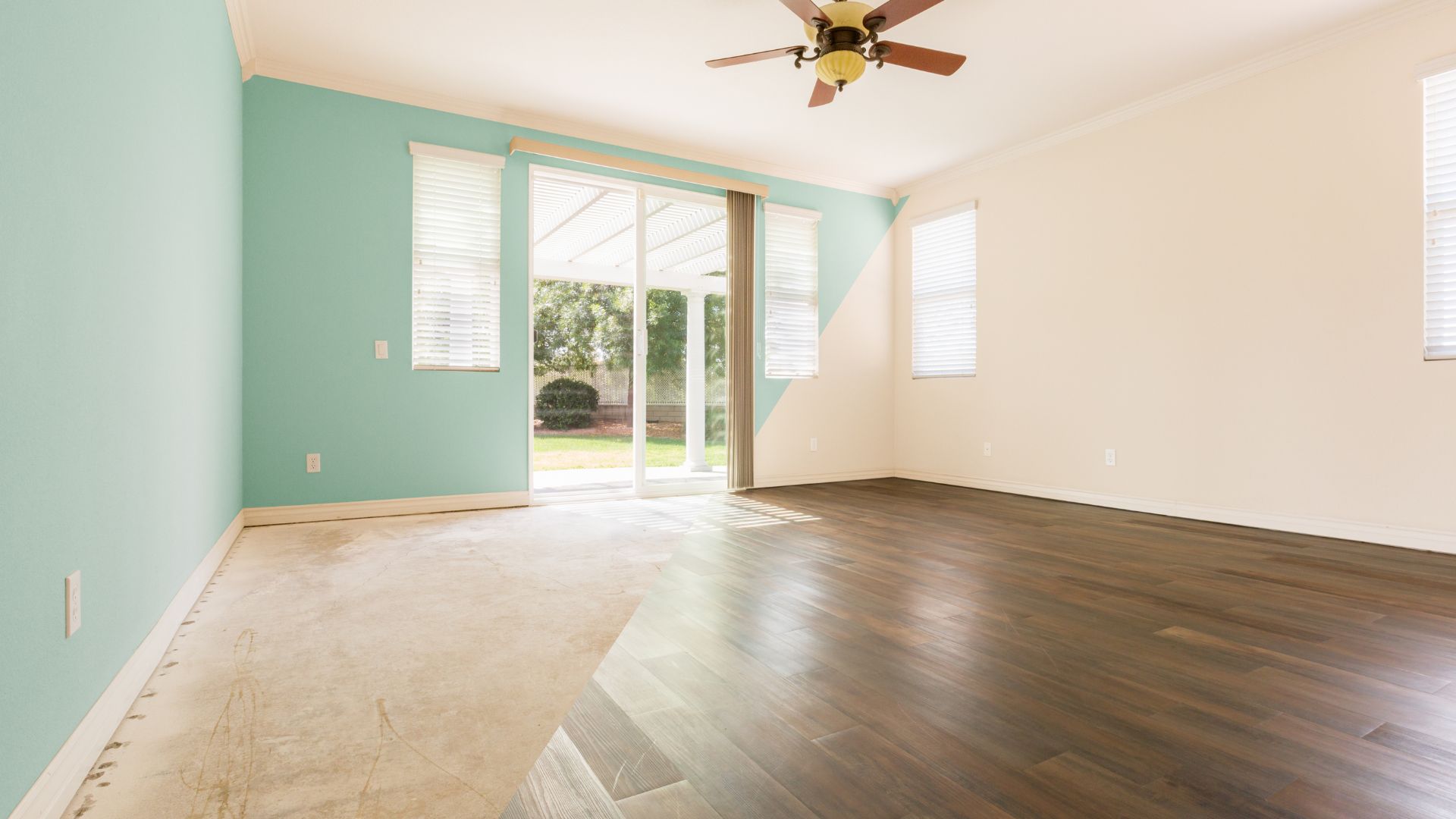 An empty room with a ceiling fan and hard wood floors