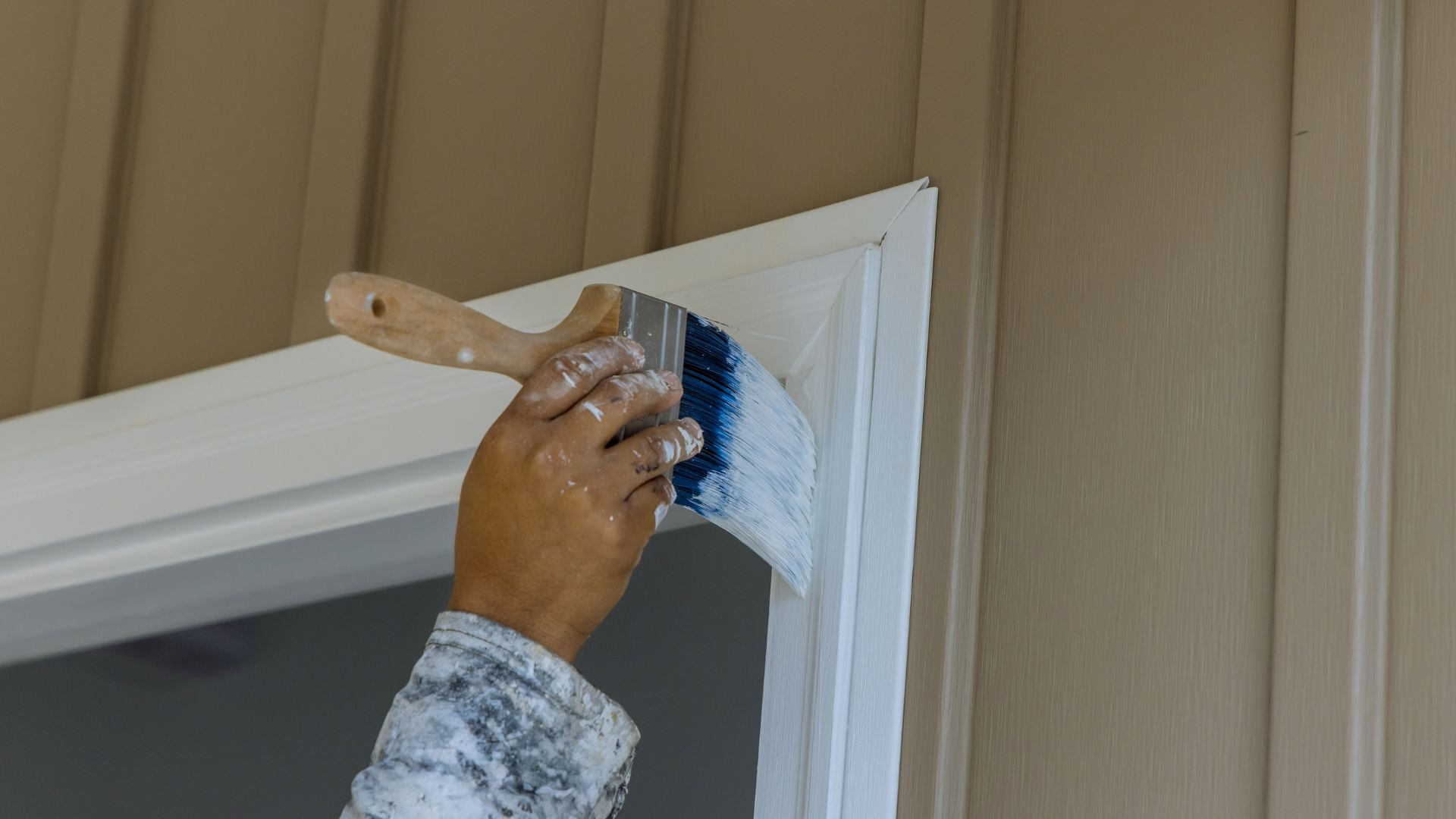 A person with a paint brush painting a window